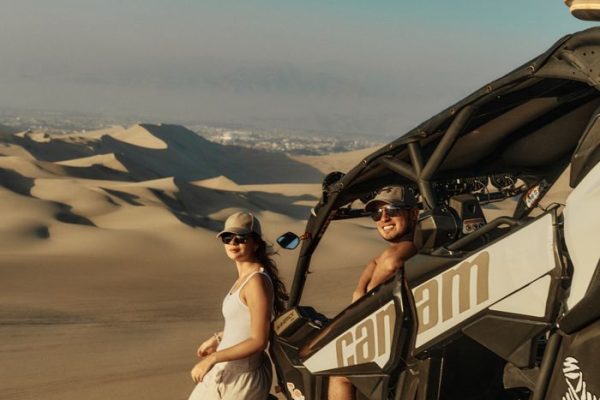 Couple enjoys an exciting off-road adventure in a desert dune buggy, capturing the thrill of outdoor exploration.